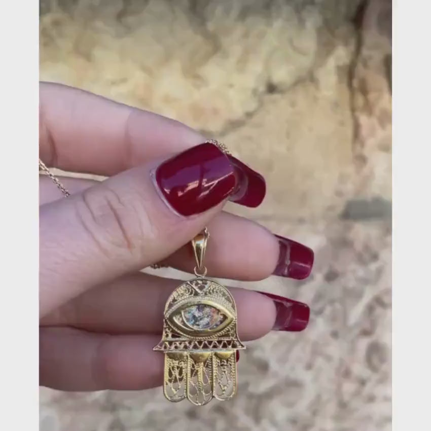 Load video: Hamsa and Evil Eye Roman Glass Pendant in 14k Gold Filigree